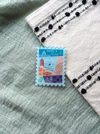 illustrated Rhode Island Acrylic Stamp Magnet held and textured fabric behind