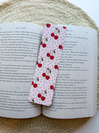 Book with a cherry-themed bookmark on a textured surface