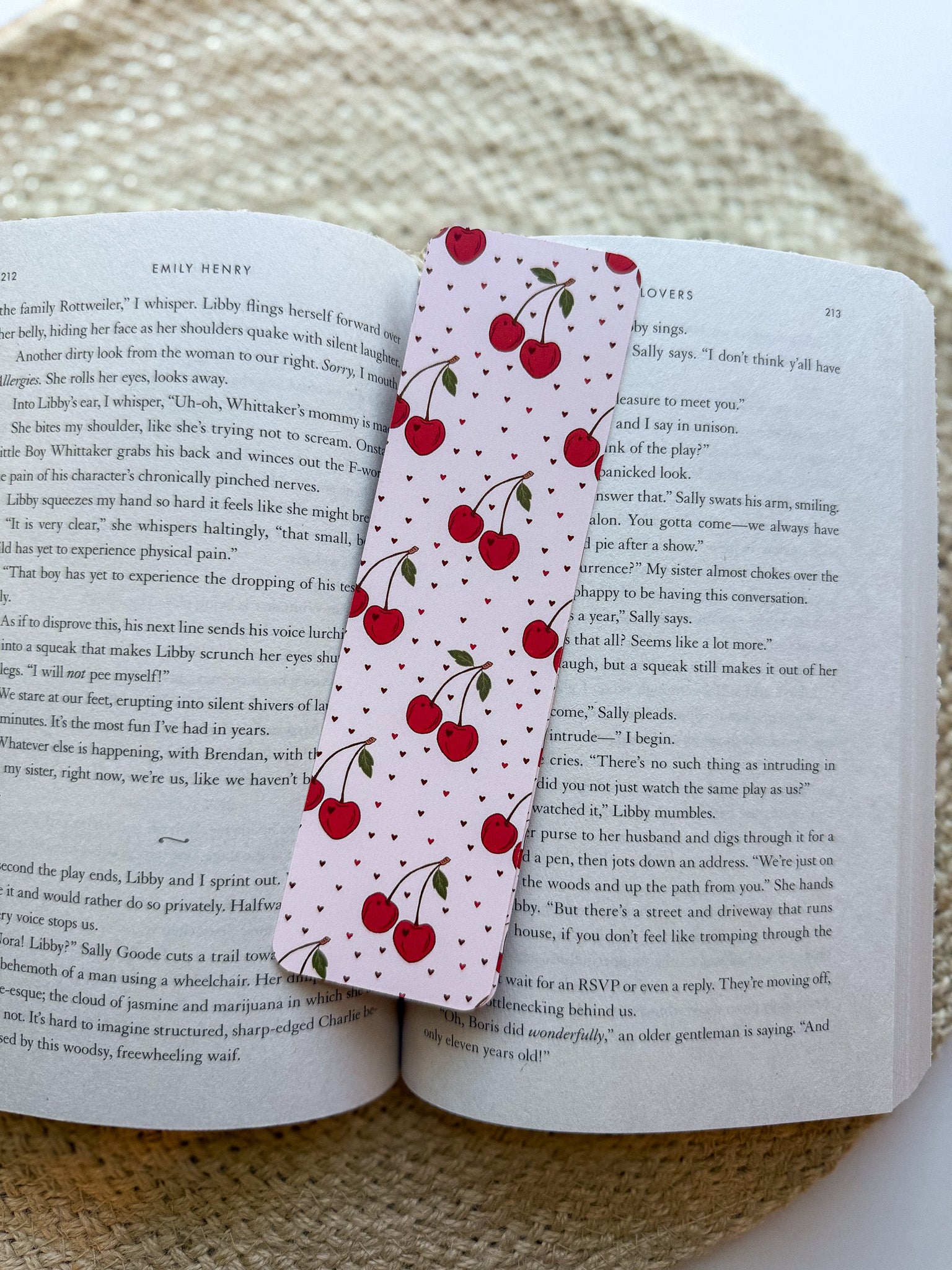 Book with a cherry-themed bookmark on a textured surface