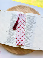 Open book with a cherry-patterned bookmark on a wooden surface