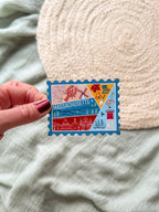 Colorful Massachusetts stamp-shaped magnet on a textured surface