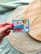 Colorful Massachusetts stamp shaped magnet on a textured surface