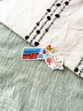 Colorful Massachusetts-shaped sticker on a textured surface