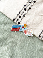Colorful Massachusetts-shaped sticker on a textured surface