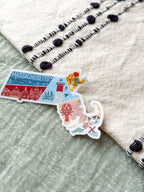 Colorful Massachusetts-shaped sticker on a textured surface