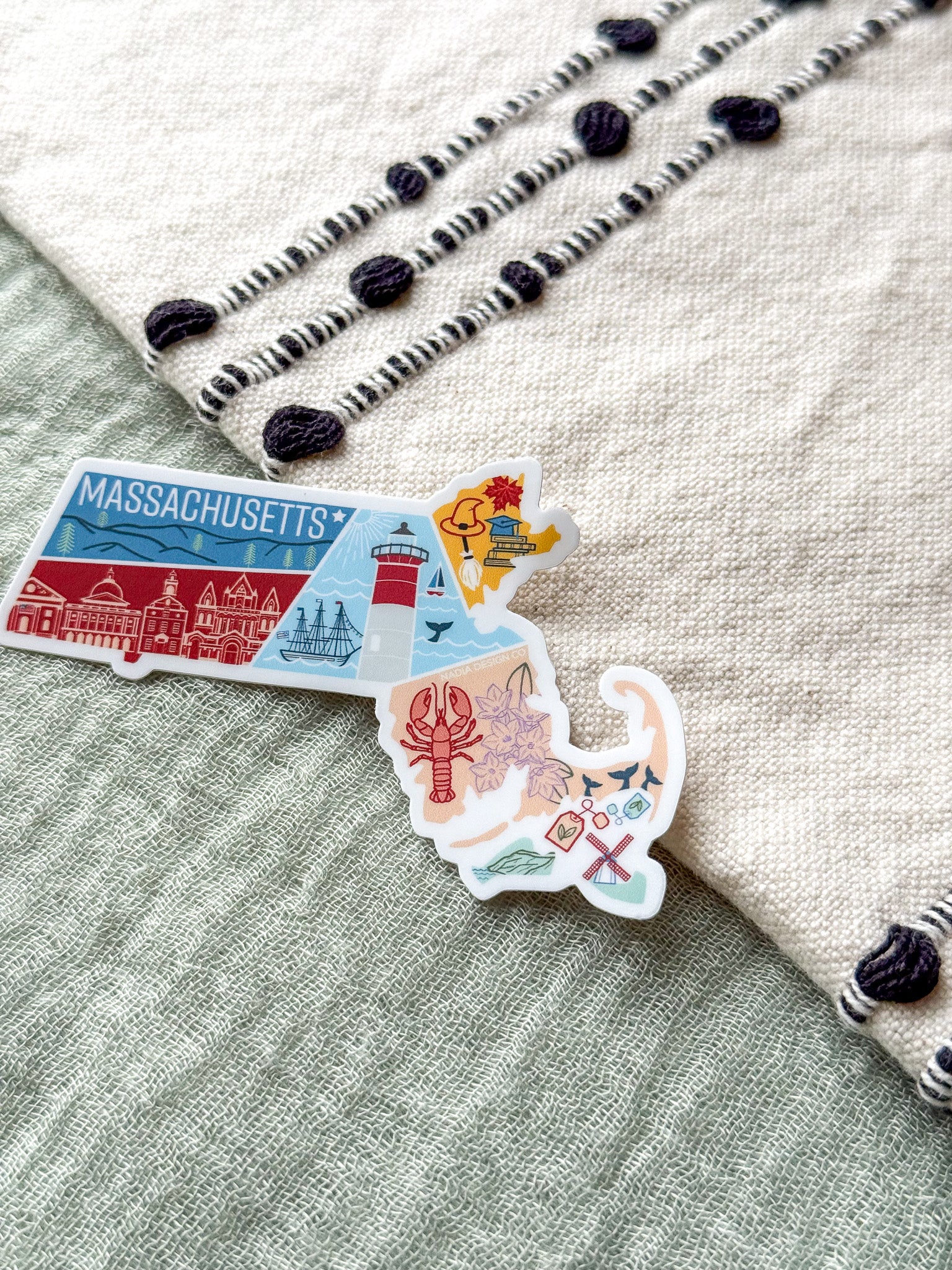 Colorful Massachusetts-shaped sticker on a textured surface