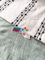 Colorful Massachusetts-shaped sticker on a textured surface