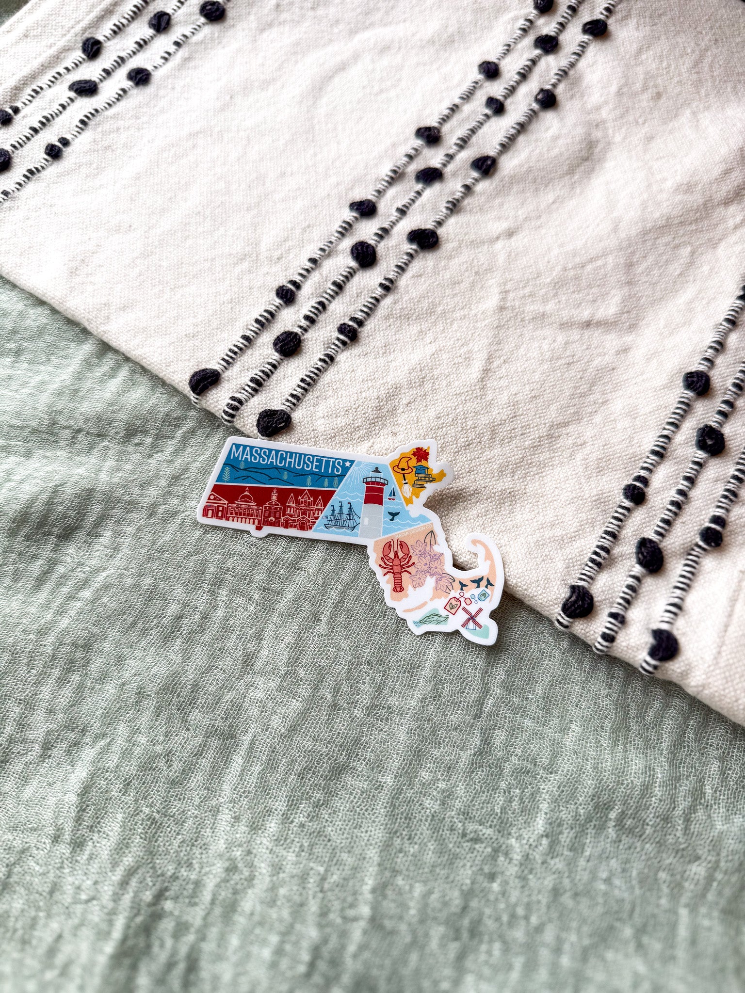 Colorful Massachusetts-shaped sticker on a textured surface