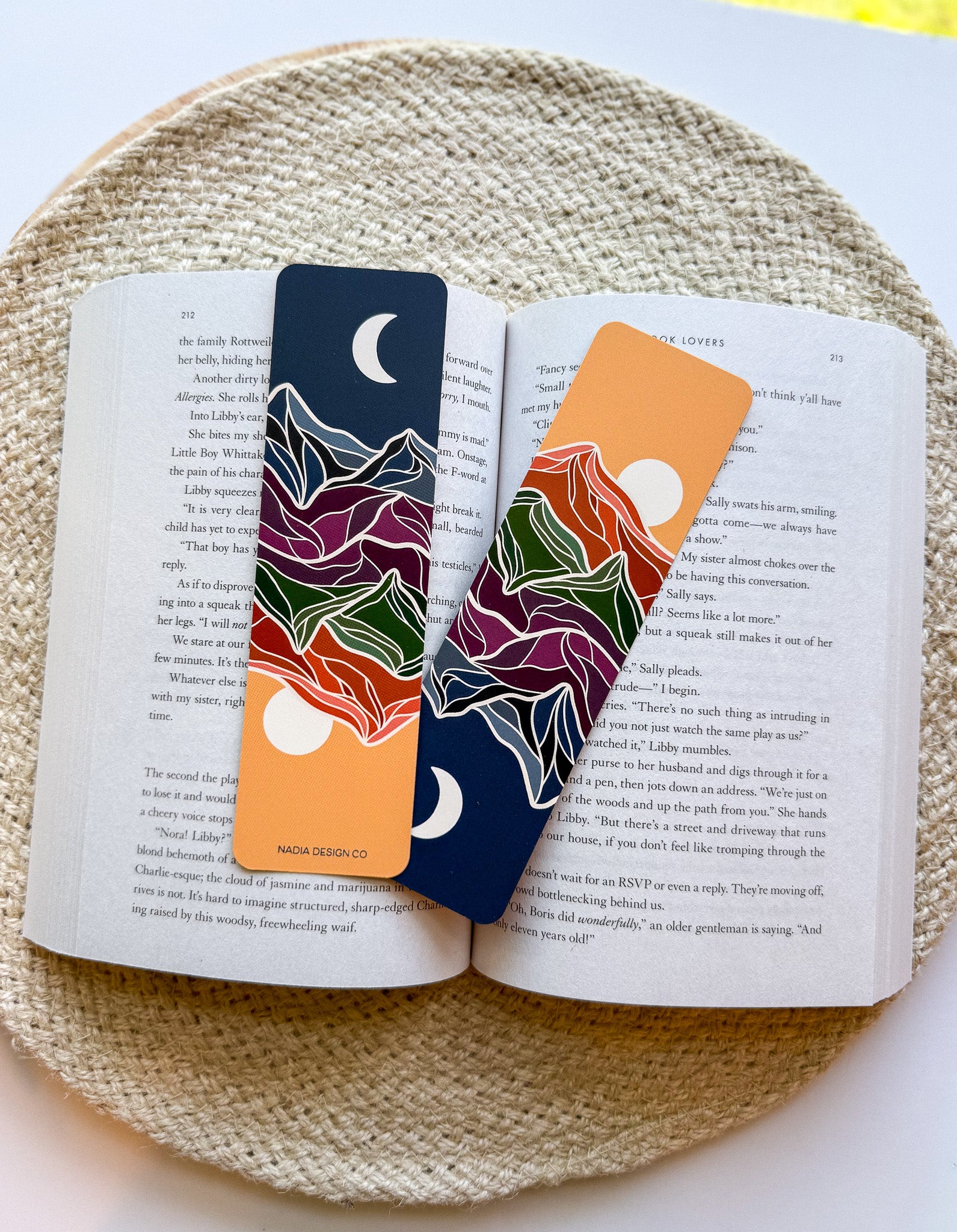 Two colorful bookmarks with mountain designs on an open book.