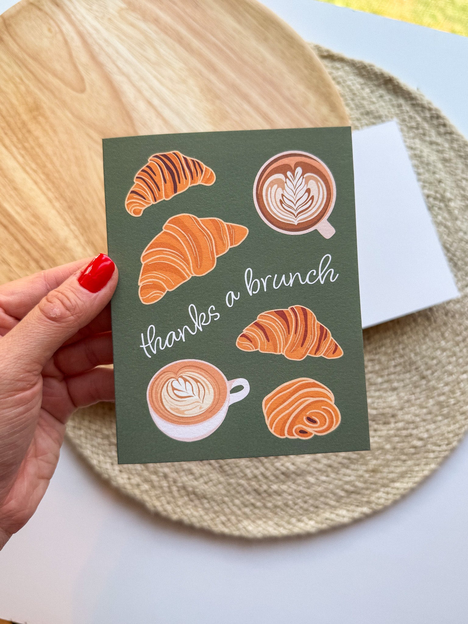 Greeting card "thanks a brunch" pun with croissant and coffee illustrations on a wooden background