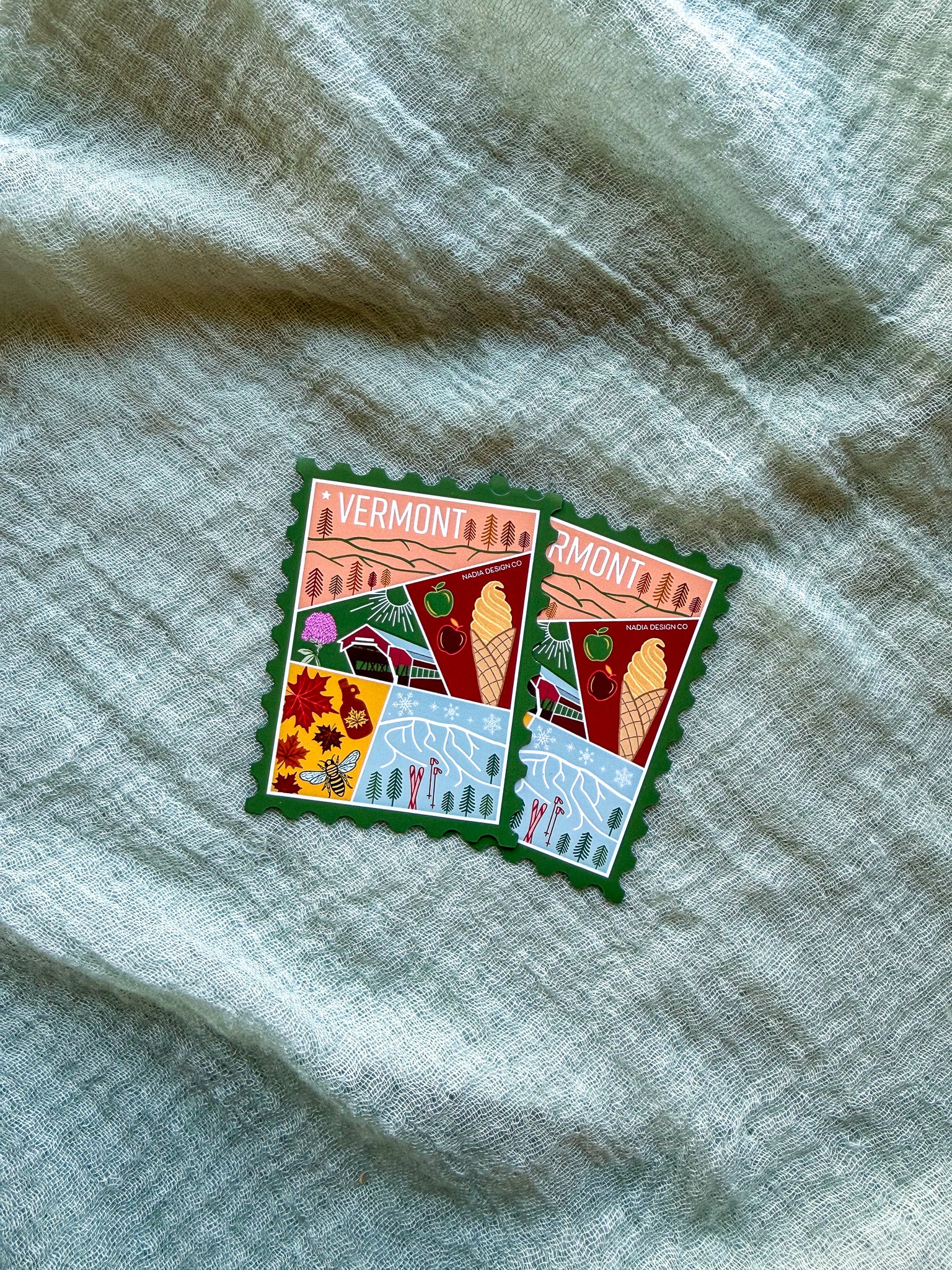 Colorful Vermont-themed stamp magnet  on a textured fabric background