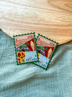 Colorful Vermont-themed stamp magnet  on a textured fabric background