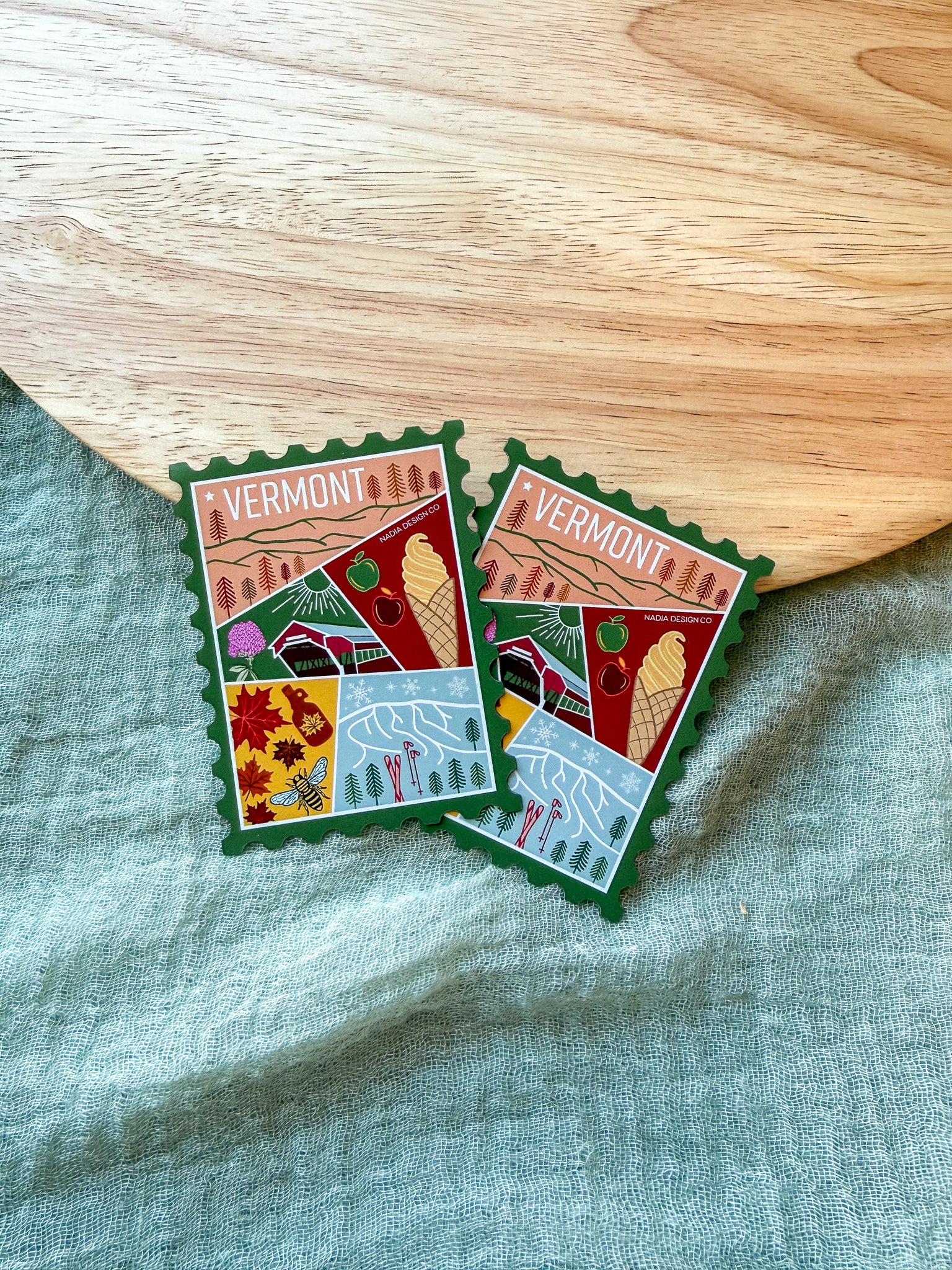 Colorful Vermont-themed stamp magnet  on a textured fabric background