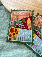 Colorful Vermont-themed stamp magnet  on a textured fabric background