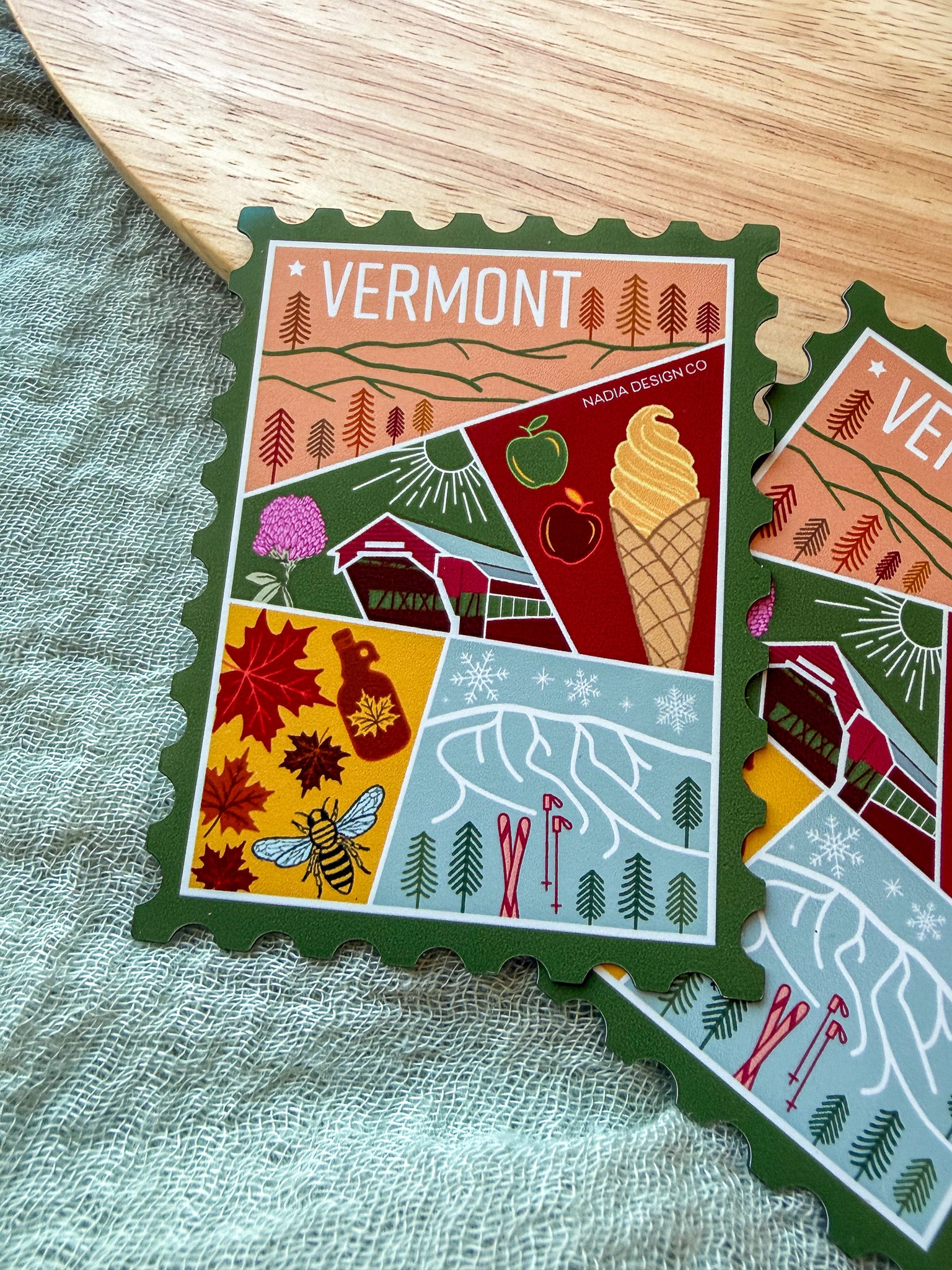 Colorful Vermont-themed stamp magnet  on a textured fabric background