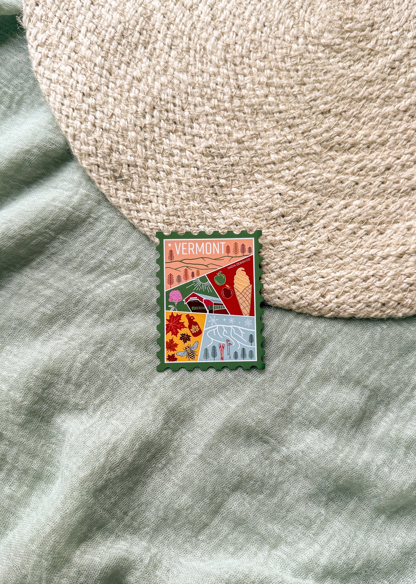 Colorful Vermont-themed stamp magnet  on a textured fabric background