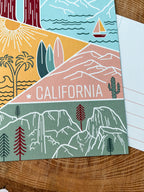 A colorful postcard featuring an illustration of California's landscape, including mountains, a beach, and iconic symbols like palm trees and a sailboat.