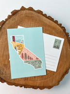 A colorful postcard featuring an illustration of California's landscape, including mountains, a beach, and iconic symbols like palm trees and a sailboat.