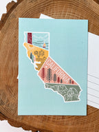 A colorful postcard featuring an illustration of California's landscape, including mountains, a beach, and iconic symbols like palm trees and a sailboat.