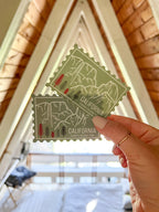 A vinyl sticker with an illustration of Yosemite National Park, California, held against a light background.