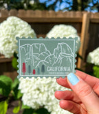 A vinyl sticker with an illustration of Yosemite National Park, California, held against a light background.