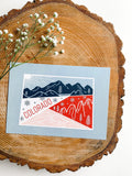 A colorful postcard featuring an illustration of Colorado landscape.