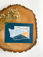 Illustrated washington state postcard on a wooden slab
