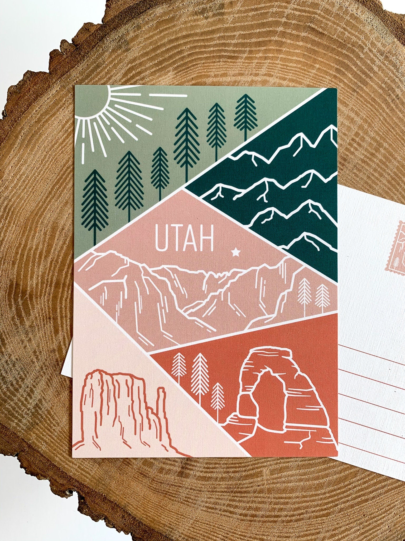 A postcard featuring a colorful illustration of Utah's landscape, including mountains and trees, with the word 'UTAH' prominently displayed.