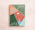 A postcard featuring a colorful illustration of Arizona's landscape, including mountains and cacti, with the text 'ARIZONA' at the top.