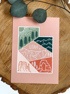 A postcard with an illustrated mountain range and the text 'UTAH' prominently featured. The design includes a mix of colors representing the landscape, and a logo is visible on the bottom.