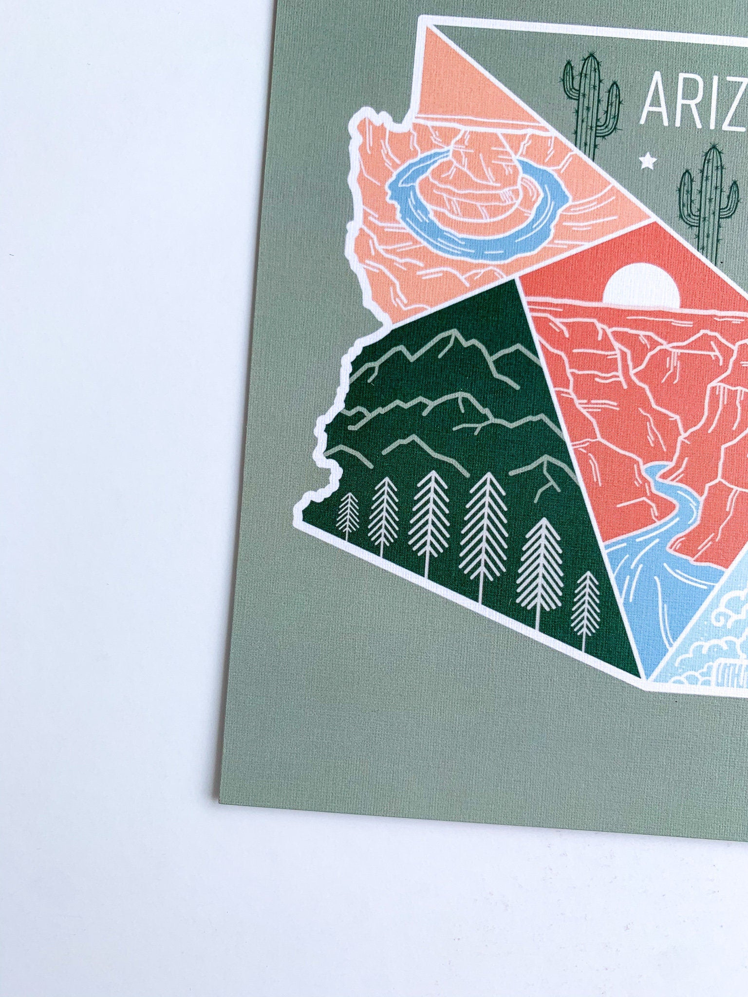 A postcard with an illustration representing Arizona's landscape, including a cactus and mountains, with a space for personalized messaging on the back.