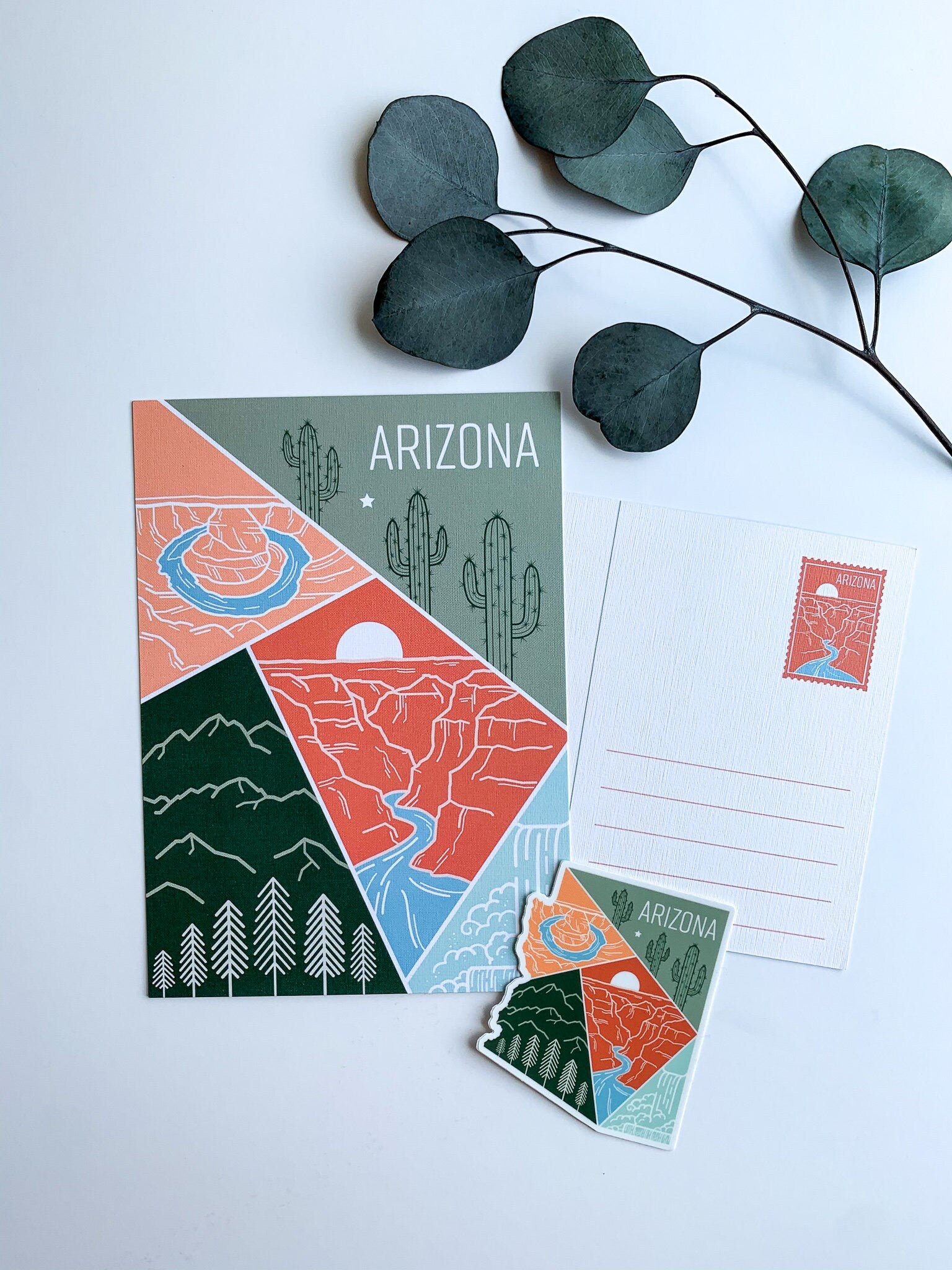 A postcard featuring a colorful illustration of Arizona's landscape, including mountains and cacti, with the text 'ARIZONA' at the top.