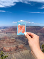 A magnet shaped like a postage stamp with an illustration of the Grand Canyon National Park, Arizona, die-cut to the shape of the stamp.