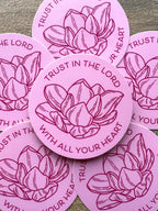 A set of pink vinyl stickers with a floral design and the text 'TRUST IN THE LORD WITH ALL YOUR HEART' written on them.
